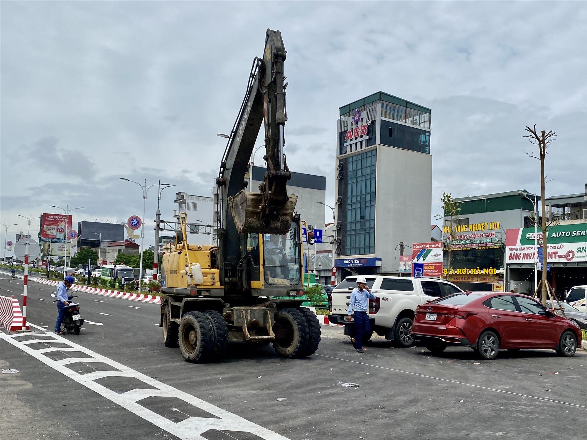 Công nhân cùng nhiều phương tiện máy móc gấp rút những hạng mục cuối cùng trên cầu Vĩnh Tuy 2. Ảnh: Vĩnh Hoàng