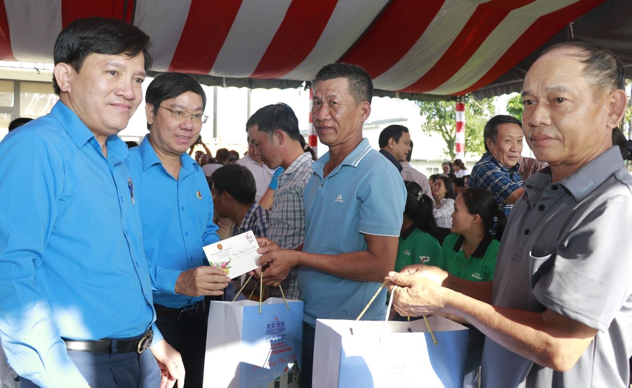 Ông Nguyễn Xuân Hùng (bìa trái ảnh) và ông Nguyễn Thế Lập - Chủ tịch LĐLĐ tỉnh Quảng Trị trao quà Tết của Tổng LĐLĐ Việt Nam cho người lao động. Ảnh: Hưng Thơ.