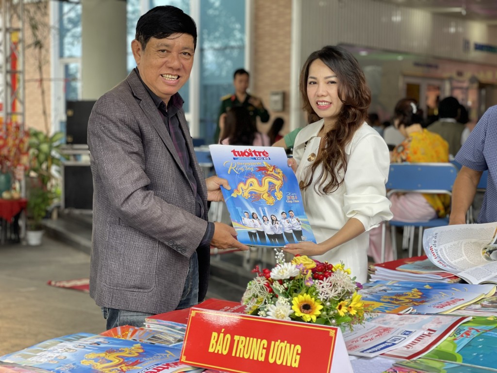 Độc giả Đặng Phi Hoàng (bên trái) bày tỏ vui mừng khi nhận được ấn phẩm đặc biệt báo Tuổi trẻ Thủ đô xuân Giáp Thìn 2024 (Ảnh Đ.Minh)