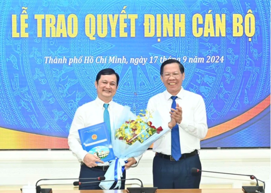Ông Phan Văn Mãi trao quyết định và tặng hoa chúc mừng ông Kiều Nam Thành. Ảnh: Việt Dũng
