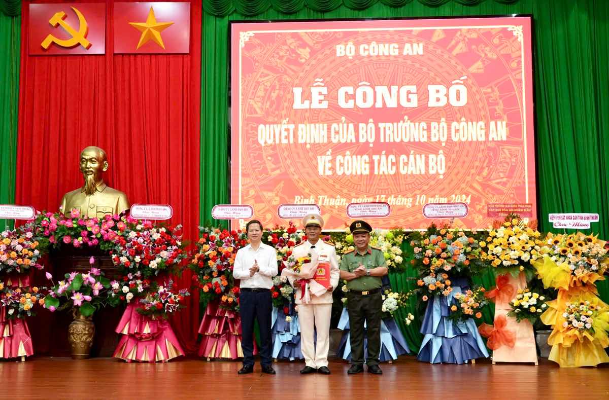 Đại tá Lê Quang Nhân, Giám đốc Công an tỉnh Bình Thuận và ông Đoàn Anh Dũng, Chủ tịch UBND tỉnh Bình Thuận trao hoa chúc mừng và thừa ủy quyền của Bộ trưởng Bộ Công an trao Quyết định điều động cho Đại tá Nguyễn Anh Tuấn. Ảnh: Văn Hoàn