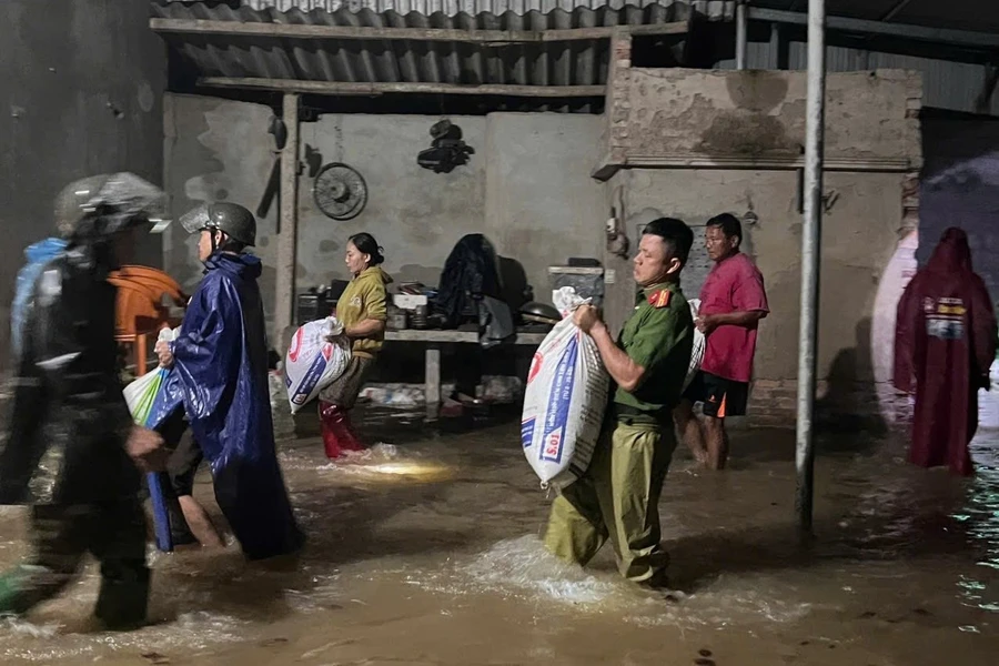 Công an Hà Tĩnh và các lực lượng chức năng hỗ trợ người dân sơ tán của cải do mưa lớn nước dâng trong đêm. (Ảnh: CAHT)