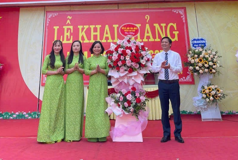 Hiệu trưởng Đinh Thị Thanh Bình (thứ 3 từ trái qua) nhận hoa chúc mừng từ lãnh đạo huyện Lâm Thao. 1.jpg