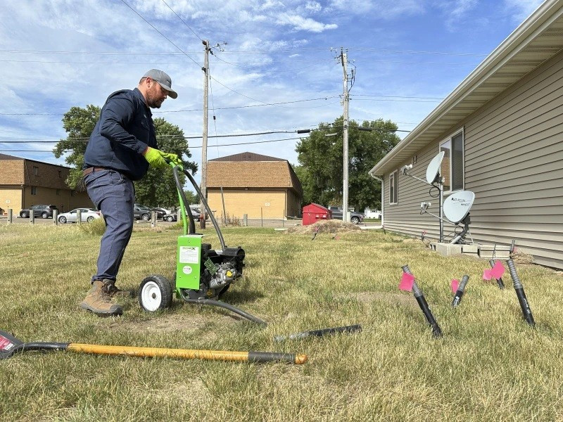 Ông Joshua Herman bơm khí carbon monoxide vào hang do sóc đất Richardson đào dọc theo một tòa nhà chung cư tại Minot, Bắc Dakota (Ảnh AP/Jack Dura) hang-trieu-soc-dat-tung-hoanh-thanh-pho-my-phai-cau-cuu-chuyen-gia-3.jpg