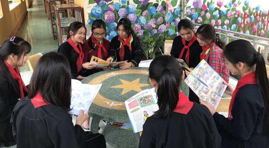 Học sinh đọc sách tại khuôn viên thư viện ngoài trời. Ảnh NT.