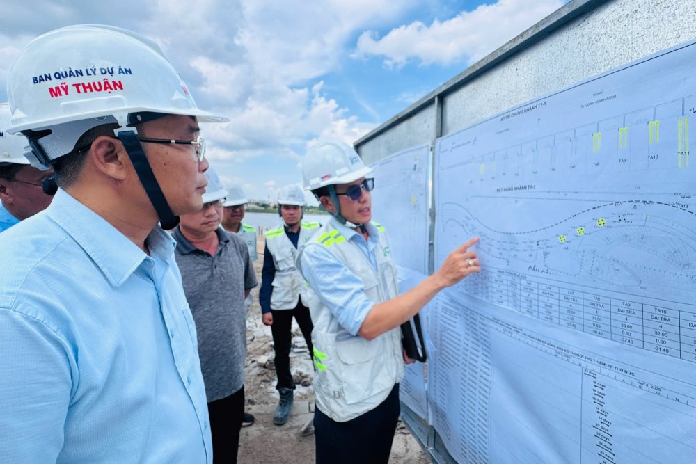 Ông Trần Văn Thi – Giám đốc Ban QLDA Mỹ Thuận nghe đại diện nhà thầu báo cáo tiến độ thi công cầu đi bộ qua sông Sài Gòn. Ảnh: LĐO Hỏi ChatGPT