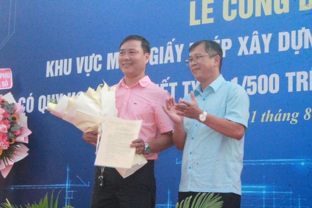 Ông Ngô Thế Minh (ngụ phường Bình Phú) nhận thông báo miễn giấy phép xây dựng. Ảnh: Anh Tú