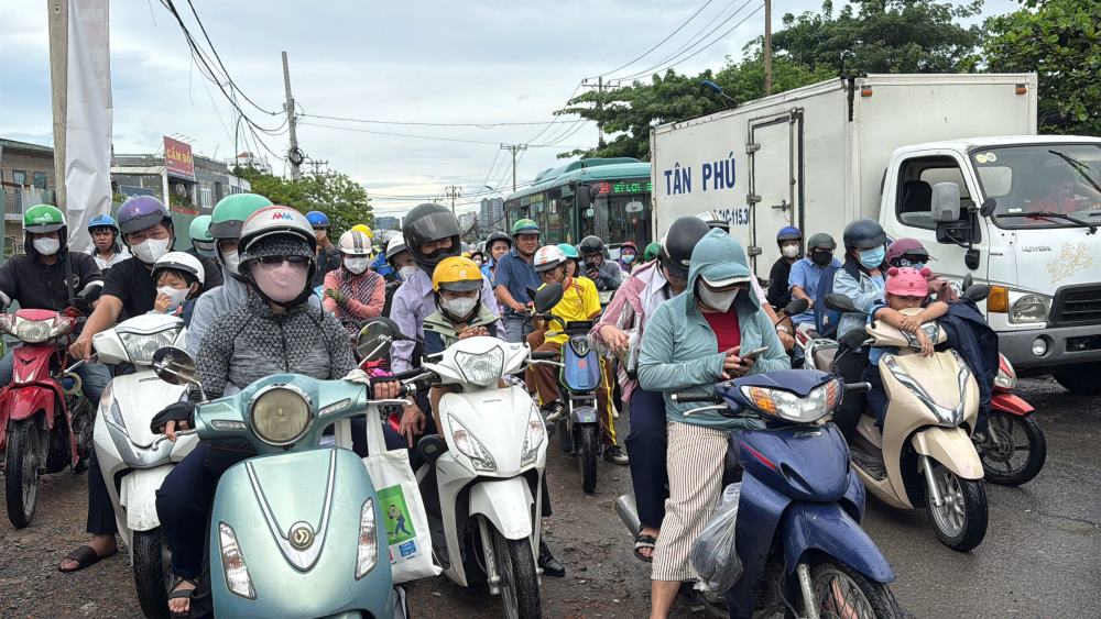 Người dân phường Bình Trưng vất vả luồn lách qua khu vực công trường để đưa con đi học.