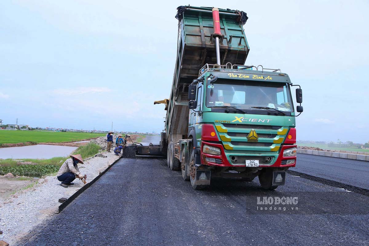 Công nhân đang thảm bê tông nhựa tại Km19+800 thuộc địa phận xã Xuân Trường. Ảnh: Lương Hà