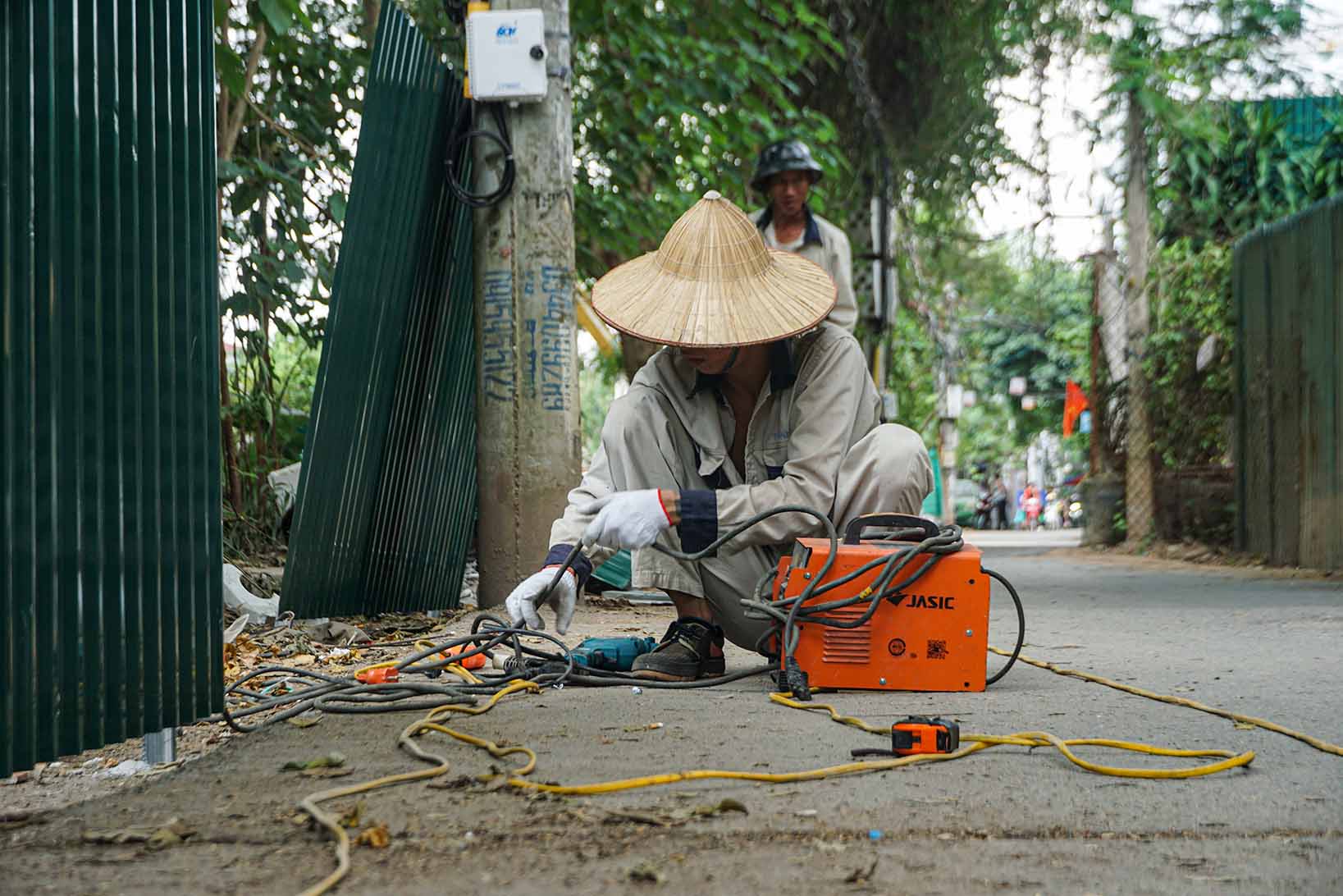 Lực lượng chức năng lắp rào chắn ngăn đổ trộm rác xuống mương ngõ 39 Tứ Liên. Ảnh: Hữu Vũ