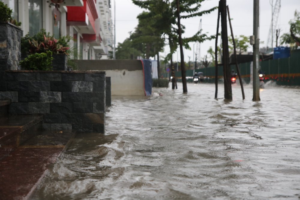 Khu đô thị Nam An Khánh (xã An Khánh) nước ngập sâu, các phương tiện di chuyển rất khó khăn, nhiều người phải tắt máy, dắt xe. Ảnh: Trần Vương