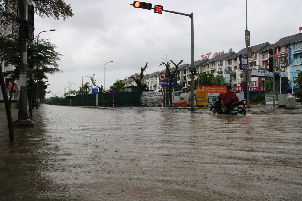 Khu đô thị Nam An Khánh (xã An Khánh) nước ngập sâu, các phương tiện di chuyển rất khó khăn, nhiều người phải tắt máy, dắt xe. Ảnh: Trần Vương