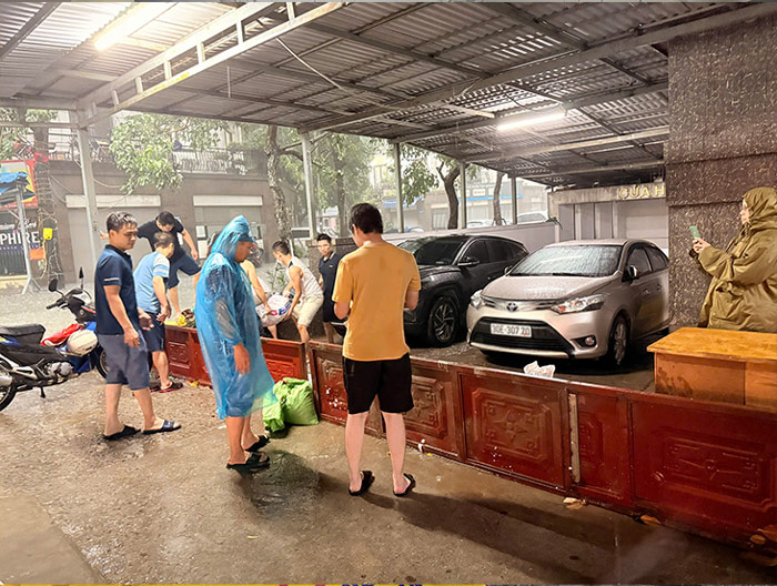 Người dân kê rào, ngăn nước ngập sâu vào các phương tiện.