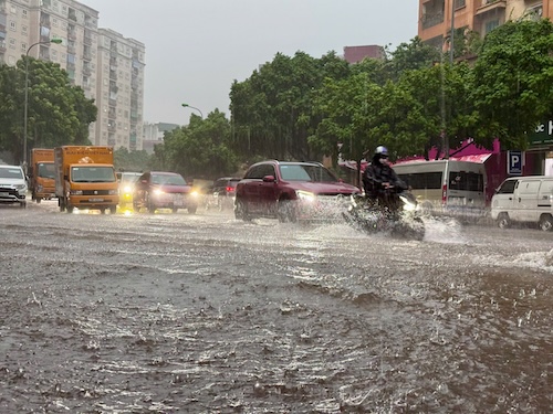 Ngã tư Trần Kim Xuyến - Vũ Phạm Hàm hiện tại đã ngập 1 nửa đường, các phương tiện di chuyển khó khăn. Ảnh: Vũ Linh