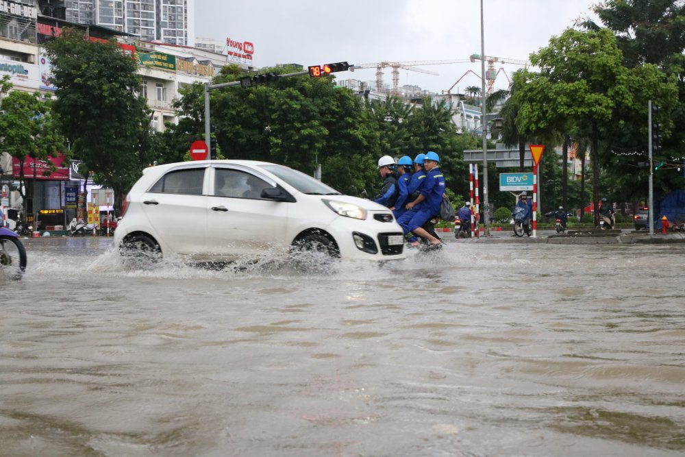 Khu đô thị Nam An Khánh (xã An Khánh) nước ngập sâu, các phương tiện di chuyển rất khó khăn, nhiều người phải tắt máy, dắt xe. Ảnh: Trần Vương