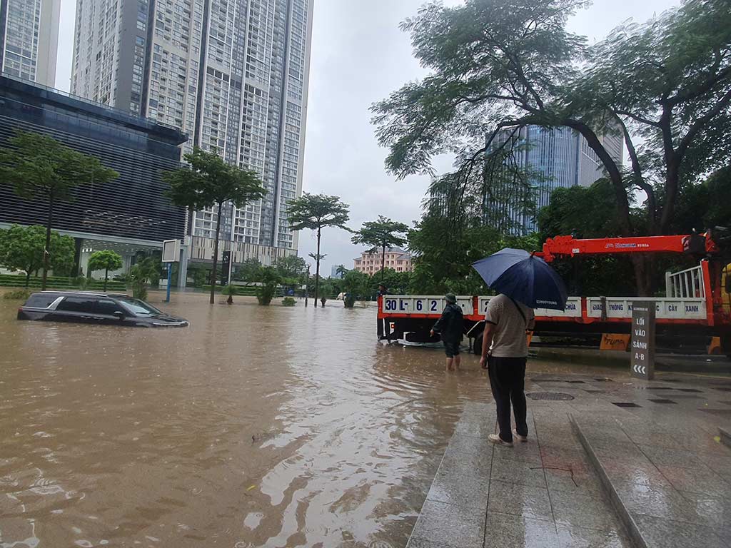 Một ôtô bị ngập sâu ở khu vực Keangnam, xe cứu hộ không thể tiếp cận gần, phải kéo dây để cứu hộ. Ảnh: Phạm Đông