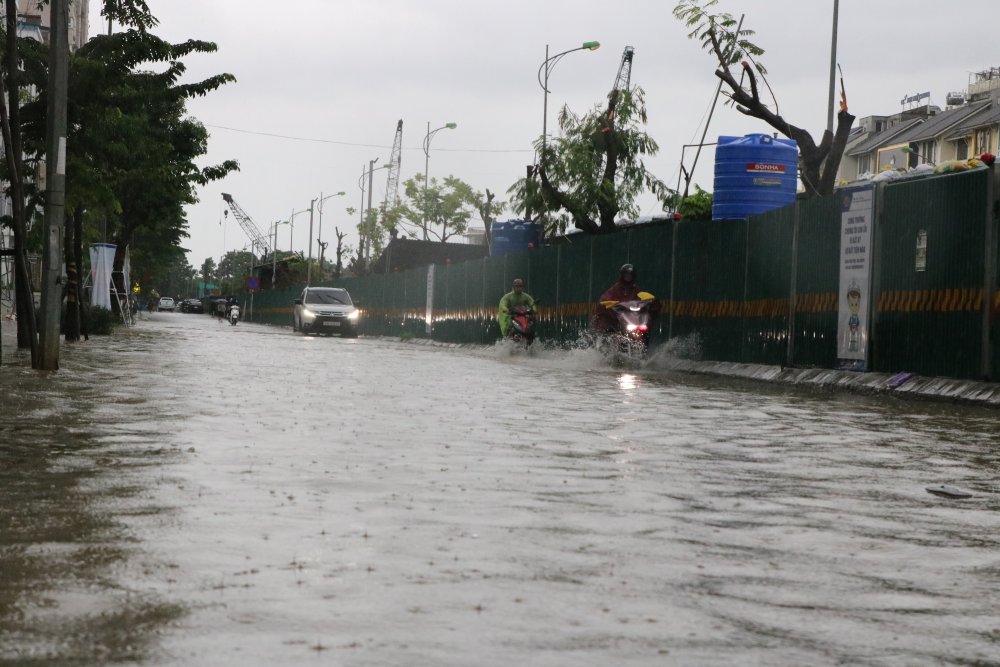 Khu đô thị Nam An Khánh (xã An Khánh) nước ngập sâu, các phương tiện di chuyển rất khó khăn, nhiều người phải tắt máy, dắt xe. Ảnh: Trần Vương