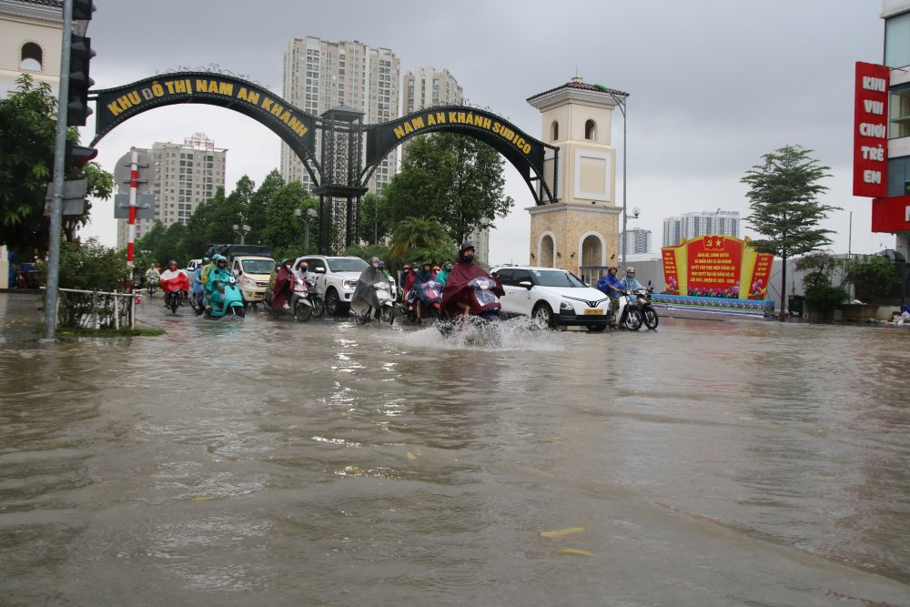 Khu đô thị Nam An Khánh (xã An Khánh) nước ngập sâu, các phương tiện di chuyển rất khó khăn, nhiều người phải tắt máy, dắt xe. Ảnh: Trần Vương