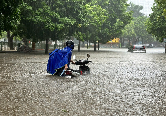 Tại nút giao đường Thành Thái -  Hoàng Quán Chi, nước ngập gần bụng người trưởng thành. Ảnh: Đinh Thiện - Thiều Trang