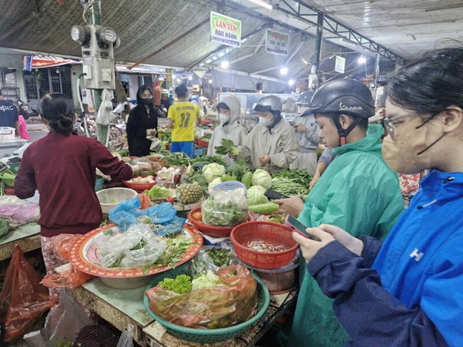Người dân mua rau xanh ở chợ Hòa Cường (Đà Nẵng) tối 22.10. Ảnh: Thu Giang