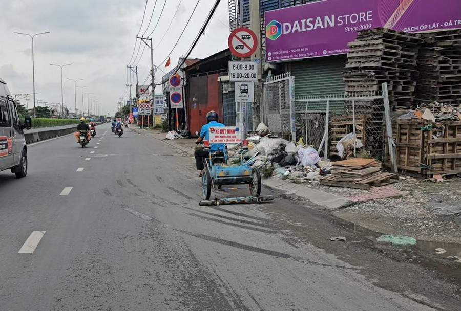 Xe hút đinh làm việc trên đường Đỗ Mười. Ảnh: Phúc Uyên. hut-dinh.jpg