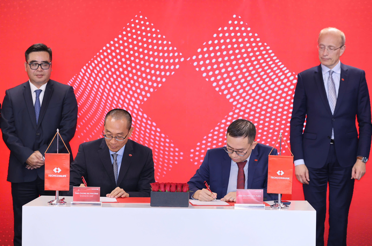 Đại diện Techcombank và Techcom Life ký kết thoả thuận trước sự chứng kiến của ông Ngô Việt Trung - Cục trưởng Cục Quản lý, giám sát bảo hiểm, Bộ Tài chính (trái) và ông Jens Lottner - Tổng Giám đốc Techcombank.