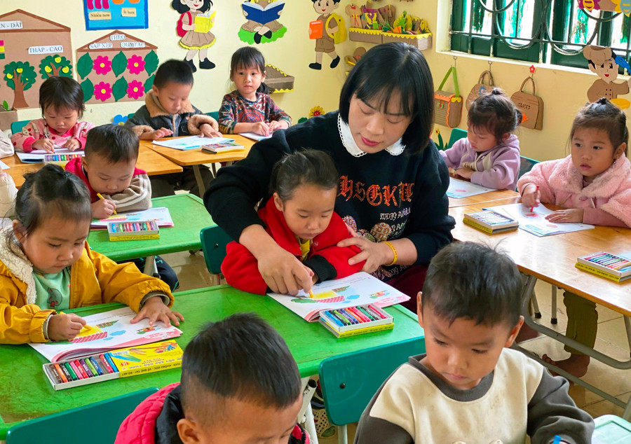 Nữ Hiệu trưởng Trường mầm non Tam Chung dạy trẻ tập tô màu. Ảnh: Phương Huyền bc87b85c8ed5028b5bc4.jpg