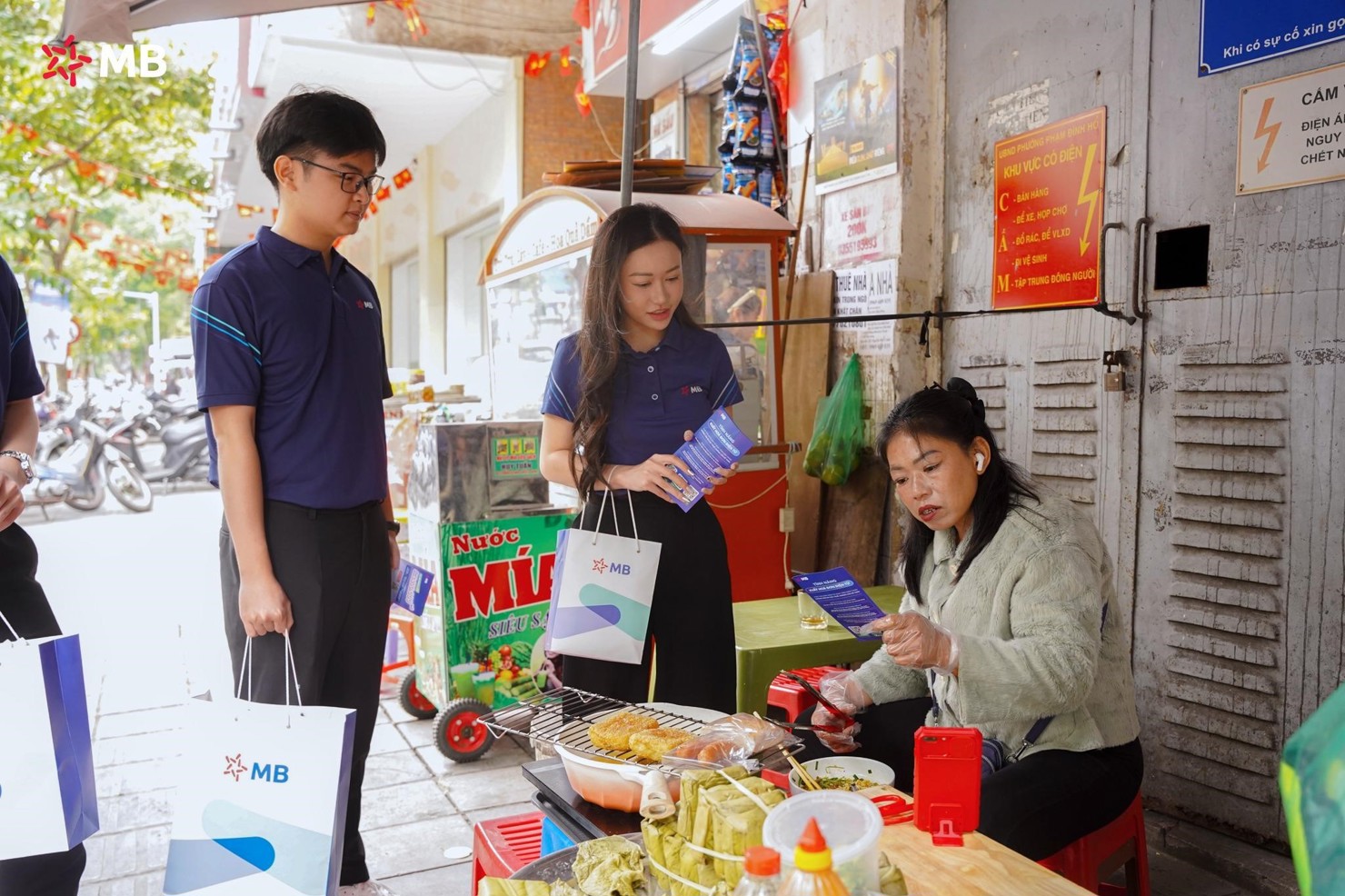 Nh&acirc;n vi&ecirc;n MB hướng dẫn tiểu thương chợ H&ocirc;m chuyển đổi số. Ảnh: MB