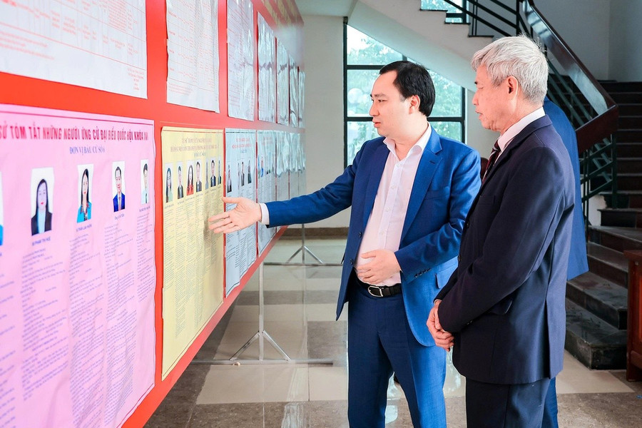 Ứng cử viên Đại biểu Quốc hội khoá XVI Vũ Văn Tiến (bên trái) trao đổi với cử tri phường Chu Văn An