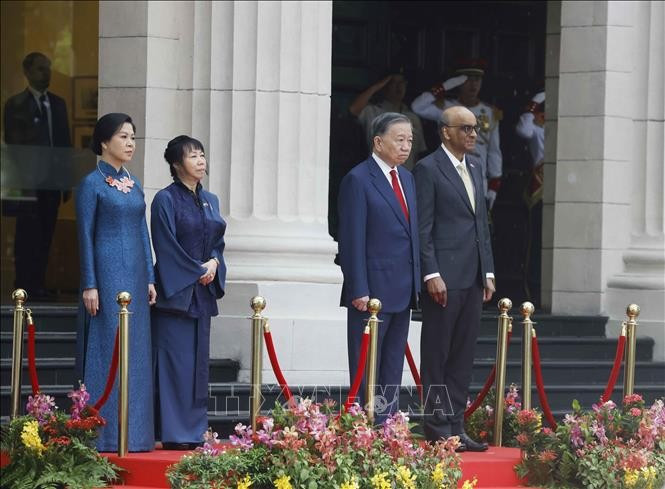 Tổng Bí thư, Chủ tịch nước Tô Lâm và Tổng thống Singapore Tharman Shanmugaratnam trên bục danh dự, nghe Quân nhạc cử Quốc thiều hai nước. Ảnh: Thống Nhất/TTXVN