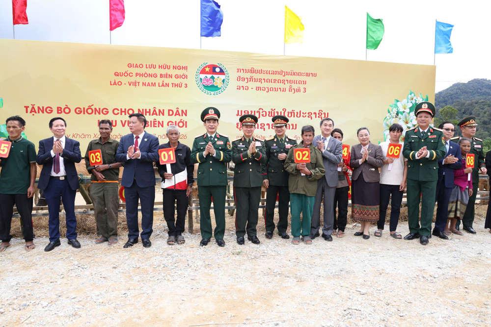 Đại tướng Phan Văn Giang và Đại tướng Khăm Liêng - Ụ Thạ Cay Sỏn trao bò giống tặng các hộ dân của Lào ở khu vực biên giới (ảnh Giang Phan). 78.jpg