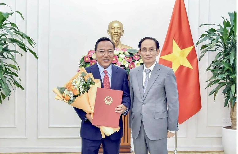 Bộ trưởng Bộ Ngoại giao Lê Hoài Trung trao quyết định của Thủ tướng Chính phủ và tặng hoa chúc mừng ông Nguyễn Hoàng Long được điều động, bổ nhiệm giữ chức Thứ trưởng Bộ Ngoại giao. Ảnh: VGP