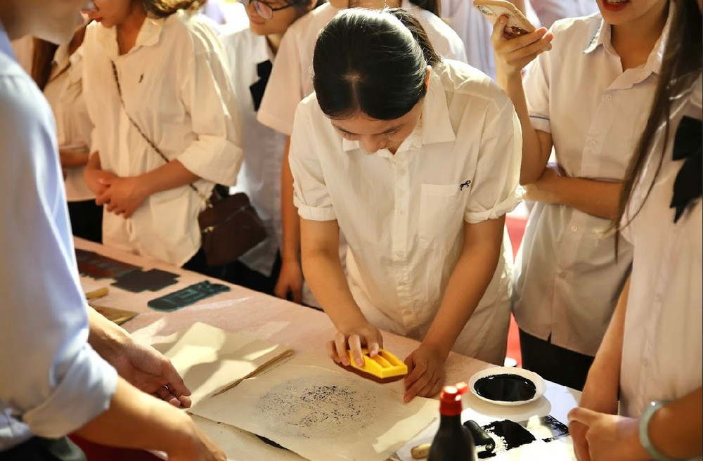 Học sinh trải nghiệm không gian khắc in tranh và biểu tượng Quốc Tử Giám trên giấy dó. Ảnh: BTC img-4424.jpg