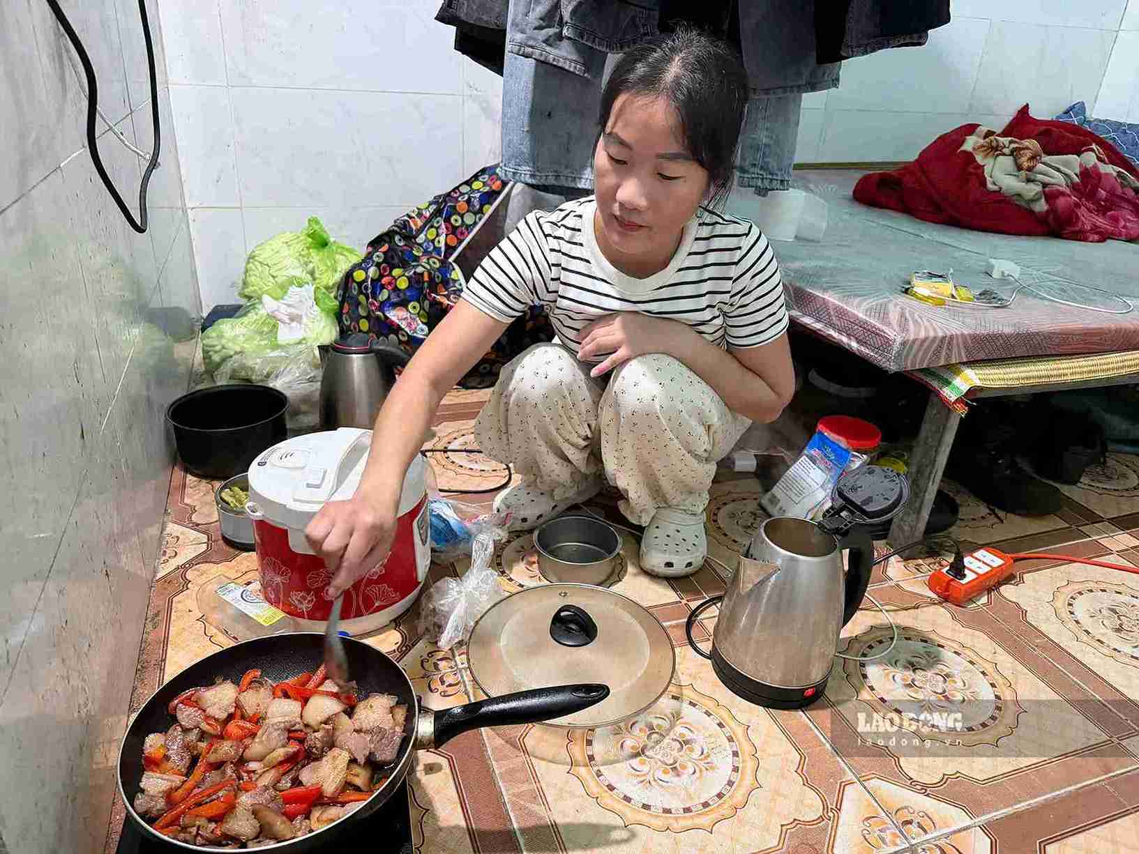 Chị Vừ Thị Thi nấu cơm trong căn phòng trọ nhỏ, nơi gia đình sinh hoạt hằng ngày. Ảnh chụp 29.9. Ảnh: Mai Hương