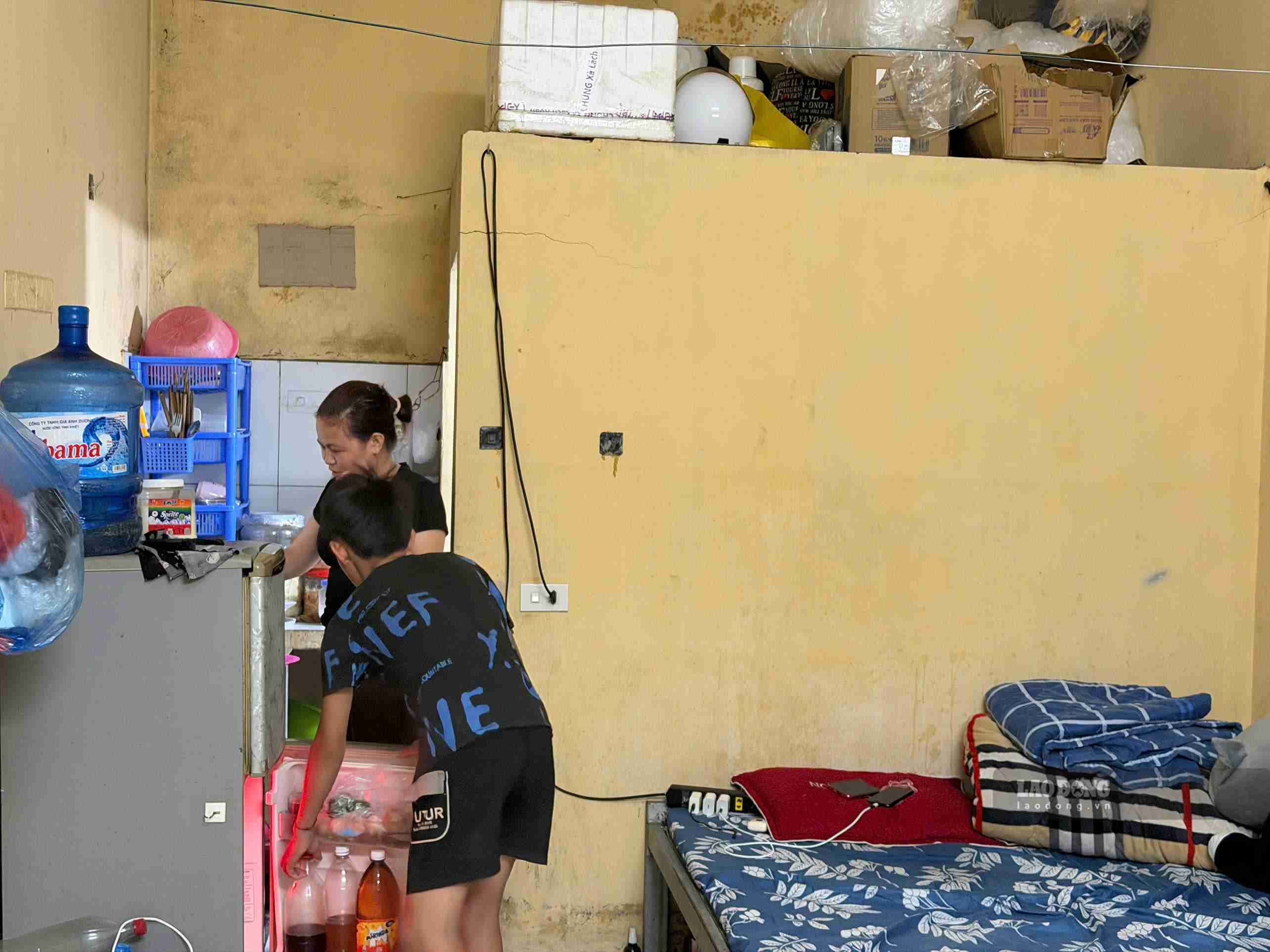 Con trai xuống thăm, cùng chị Hoàng Thị Yêu nấu cơm trong căn phòng trọ nhỏ. Ảnh: Mai Hương