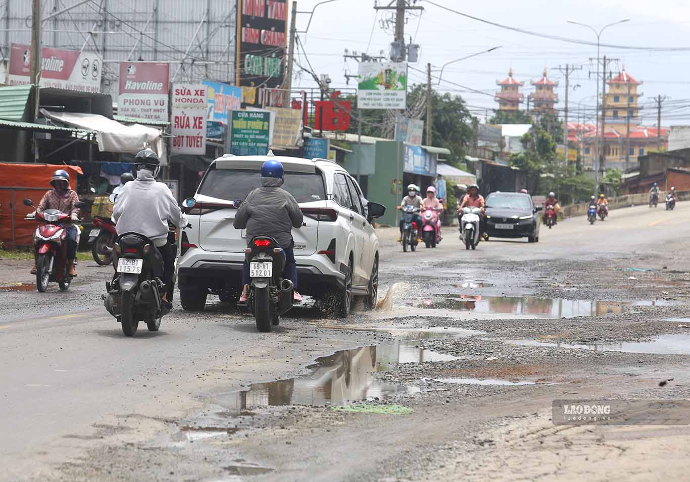 Các ổ voi, ổ gà xuất hiện dày đặc trên mặt đường tuyến quốc lộ 62 ngày 23.9, đoạn qua địa bàn ấp 5, xã Mỹ An. Ảnh: Huỳnh Du