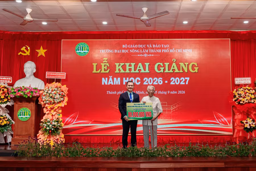 PGS.TS Đoàn Văn Điện (phải) trao học bổng 80 triệu đồng cho sinh viên dịp khai giảng tại Trường Đại học Nông Lâm TPHCM. Ảnh: NLU.