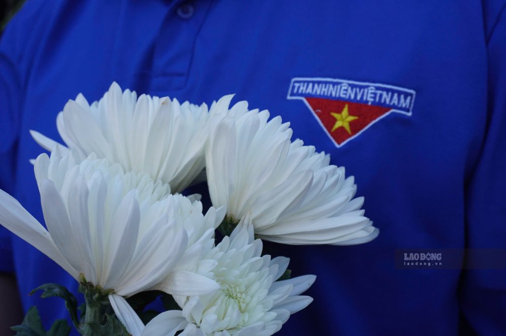 Hai bên đường đông kín người dân đứng cầm hoa trắng, tiễn đưa các liệt sĩ . Ảnh: Như Quỳnh